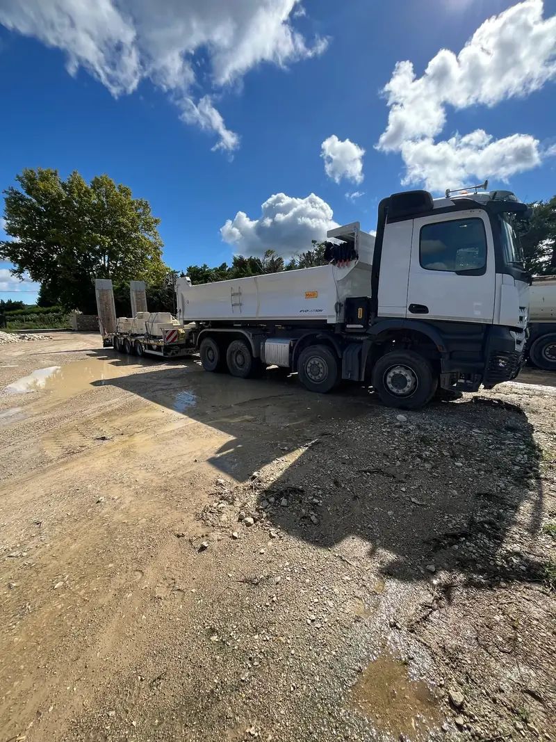 Camion benne Arocs sur un chantier boueux