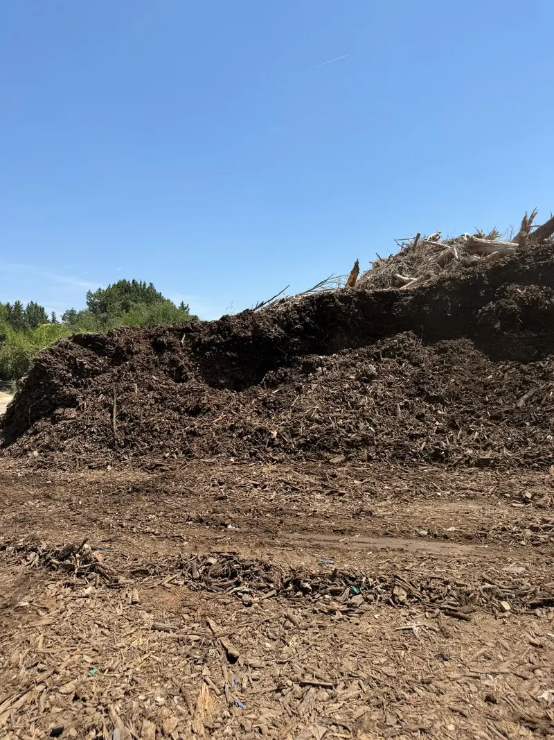 Tas de compost criblé contre le ciel bleu au dépôt Hugo BTP