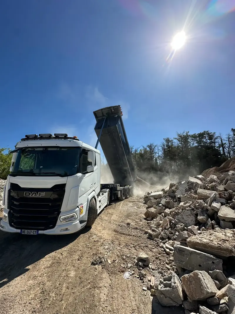 Camion benne Hugo BTP déversant des gravats sur un chantier